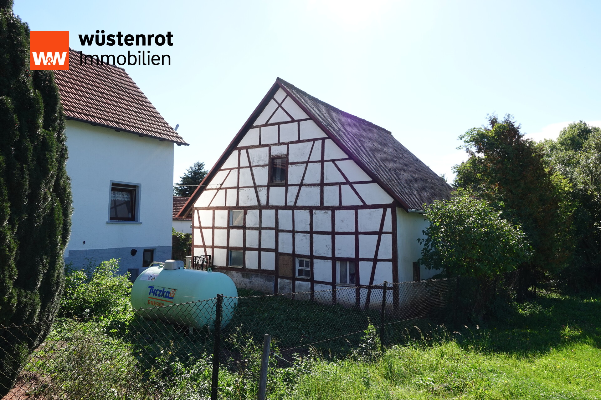 Hausansicht mit Scheune und Flüssiggastank